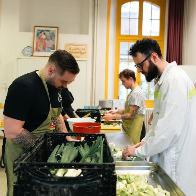 Groupe de collaborateurs et bénéficiaires cuisinant ensemble avec l'association Cœurs Résistants